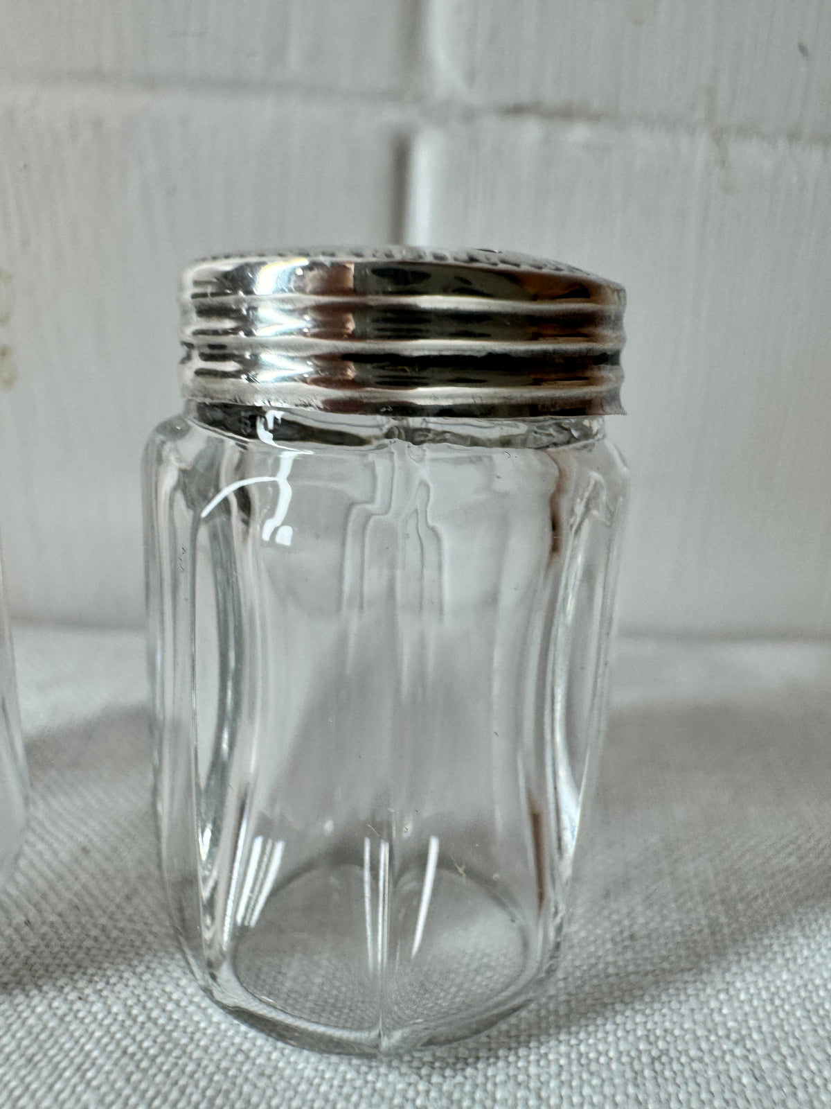Pair of antique/vintage sterling silver topped salt and pepper pots with faceted glass